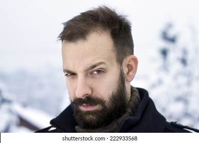 Portrait of a young man in the winter raising an eyebrow