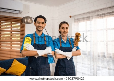 Portrait of young man and woman cleaning service worker work in house. Attractive housekeeper cleaner team wear apron and cleaning messy dirty floor for housekeeping housework and chores in house.