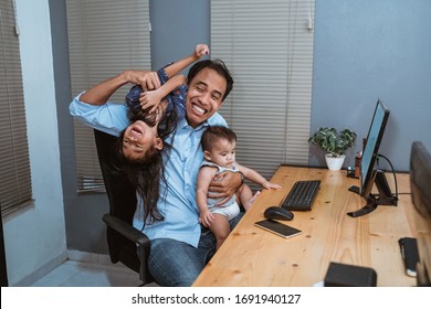 portrait of young man work from home playing with his daughter