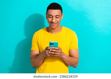 Portrait of young man yellow t-shirt writing his students friends messenger new apple iphone 14 isolated on aquamarine color background