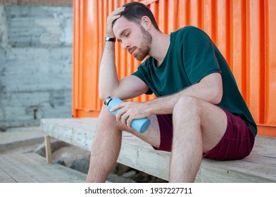 Portrait Of A Young And Masculine Man Drinking A Water Outside After Train At Gym. Relax After Running.  