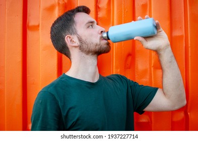 Portrait Of A Young And Masculine Man Drinking A Water Outside After Train At Gym. Relax After Running.  