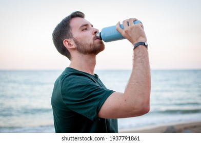 Portrait Of A Young And Masculine Man Drinking Water Outside After A Train At A Gym. Relax After Running At The Beach.