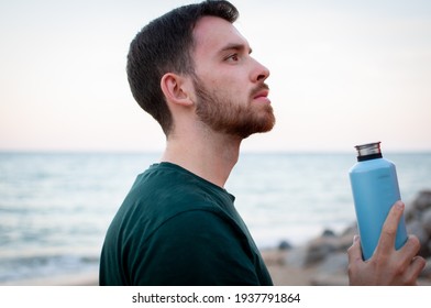 Portrait Of A Young And Masculine Man Drinking Water Outside After A Train At A Gym. Relax After Running At The Beach.