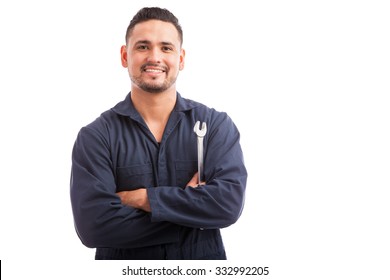 Portrait of a young mechanic holding a wrench and smiling, ready to fix cars - Powered by Shutterstock