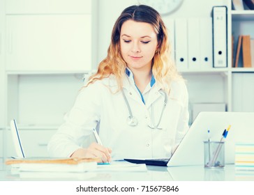 Portrait Of Young Medical Worker In Medical Center Sitting At The Table

