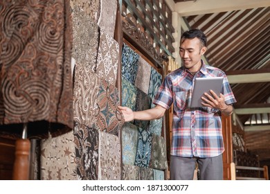 portrait of young men checking stock traditional batik cloth and clothes