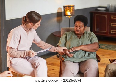 Portrait of young mental health professional talking to senior woman during therapy session