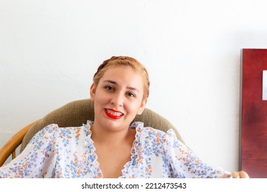 Portrait Of Young Mexican Woman Sitting Smiling Looking At Camera. Latin