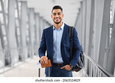 Portrait Of Young Middle Eastern Male Traveller Posing At Airport, Handsome Arab Man With Luggage, Passport And Tickets Smiling At Camera While Waiting For Flight In Terminal, Copy Space