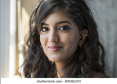 Portrait of a young middle eastern woman looking at the camera, in window light