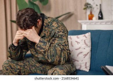 Portrait Of Young Military Man Sitting On A Coach Hiding His Face