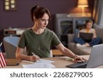 Portrait of young military woman using laptop and working at desk in office