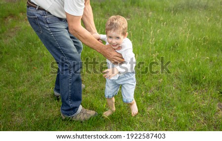 Portrait of a young mischievous child teasing and grumbling with fun look and joke. Mischievous child. Young kid in backyard smiling looking up. Childhood, family, relationships problems