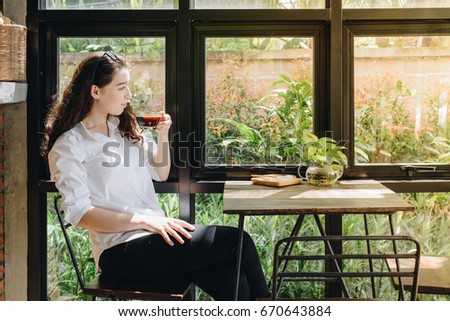 Portrait of young mixed race woman  sitting in the modern interior office while drinking a hot coffee. Conceptual of businesswoman lifestyle.