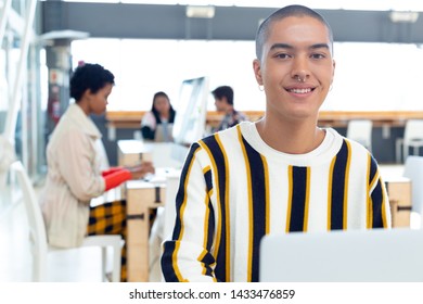 Portrait of young Mixed-race Businessman working on desk in the modern office while colleagues working on background - Powered by Shutterstock