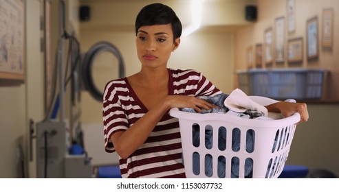 Portrait Of Young Mom Doing Laundry At Laundromat