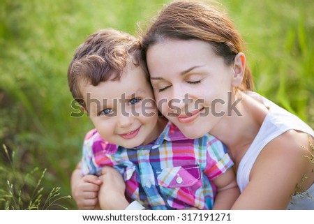 Similar – Image, Stock Photo Little boy kissing his mother on a field in summer