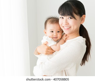 portrait of young mother hugging baby