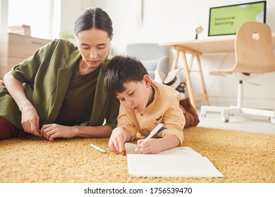 Portrait young mother laying floor and cute little boy drawing pictures  copy space