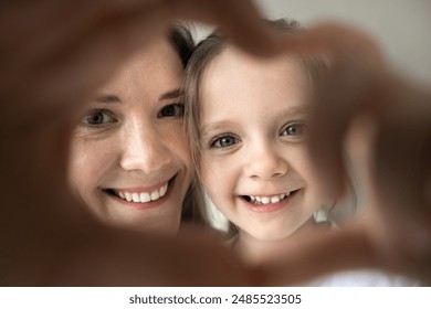 Portrait of young mother and little adorable daughter smiling looking at camera showing heart symbol with joined fingers, close up shot. Unconditional love, happy motherhood, adoption and childcare - Powered by Shutterstock