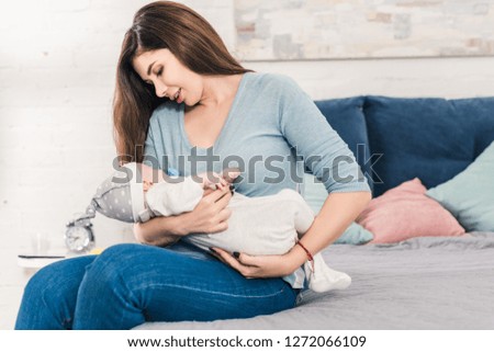 Similar – Image, Stock Photo Mother hugging her baby in front of fireplace