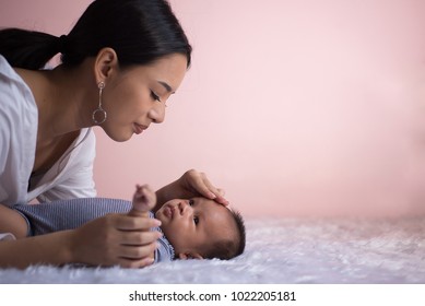 Portrait Young Mother Is Taking Care Of Sick Baby. Mom Nursing Baby. Mom And Baby Boy Relax At Home. Nursery Interior. Mother Breast Feeding Baby. Family At Home. Mom's Love.