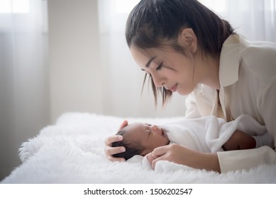 Portrait Young Mother Is Taking Care Of Sick Baby. Mom Nursing Baby. Mom And Baby Boy Relax At Home. Nursery Interior. Mother Breast Feeding Baby. Family At Home. Mom's Love.