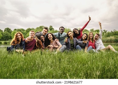 Portrait Of Young Multiracial Freedom Friends Cheering And Having Fun Resting On The Grass - Concept Of Happiness, Friendship, Union Between Different Races And Racial Inclusion