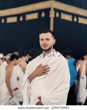 A portrait of a young Muslim man front of Kaaba in Mecca. 