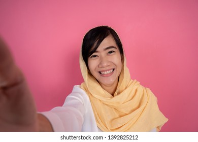 Portrait Of Young Muslim Woman Taking Selfie With Smart Phone