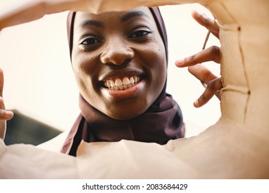 Portrait Of Young Muslim Woman Wearing Hijab Looking Inside Bag