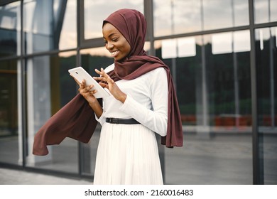 Portrait of young muslim woman wearing hijab using a tablet - Powered by Shutterstock