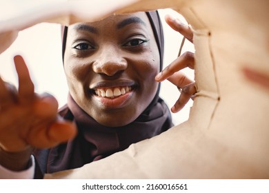 Portrait Of Young Muslim Woman Wearing Hijab Looking Inside Bag