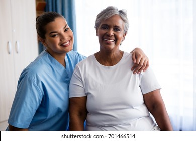 Portrait Of Young Nurse With Senior Patient In Nursing Home