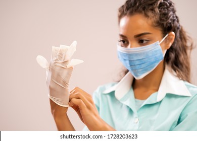 Portrait Of Young Nurse Wearing Medical Mask And Gloves.