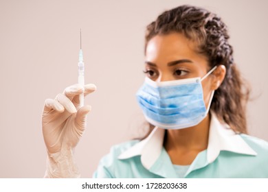 Portrait Of Young Nurse Who Is Holding Syringe. Shallow Depth Of Field.