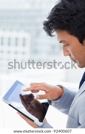 Portrait of a young office worker using a tablet computer in his office