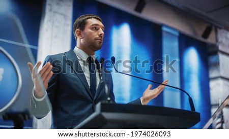 Portrait of an Young Organization Representative Speaking at Press Conference in Government Building. Press Officer Delivering a Speech at Summit. Minister Speaking at Congress Hearing.