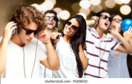 Portrait Of Young People Having A Party Against A Golden Lights