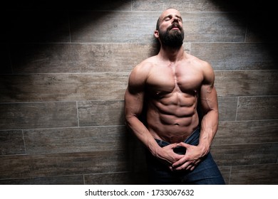 Portrait of a Young Physically Fit Man Showing His Well Trained Body While Wearing Blue Jeans - Muscular Athletic Bodybuilder Fitness Model Posing After Exercises on Wall Near the Wall 
