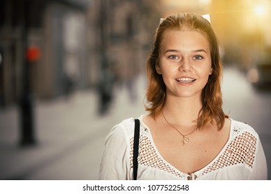 Portrait of young positive female in the modern city center