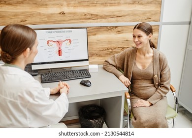 Portrait Of Young Pregnant Woman Smiling Happily During Consultation With Ob Gyn In Modern Fertility Clinic