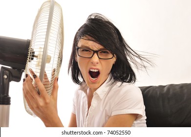 Portrait of young pretty expressive woman embracing fan at her workplace.