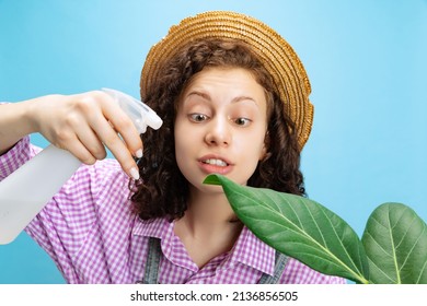 Portrait Of Young Pretty Girl, Female Gardener In Work Uniform Watering Flower Isolated On White Background. Concept Of Job, Emotions, Agronomy. Funny Meme Emotions. Copy Space For Ad