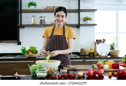 Portrait Young Pretty Lovely Woman Standing In Kitchen Holding Vagetable And Cleaning T0 Show Family Before Cooking. Cooking Food Steak Vegetables Healthy Work At Home  Stay At Home For Save Concept.