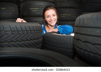 Porträt eines jungen, hübschen Mechanikers in einem Vorratsraum, umgeben von Reifen mit verschiedenen Lauten und Zwecken