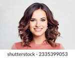 Portrait of young pretty smiling brunette model woman with makeup and long wavy bob hairstyle on white background