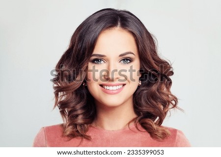 Portrait of young pretty smiling brunette model woman with makeup and long wavy bob hairstyle on white background