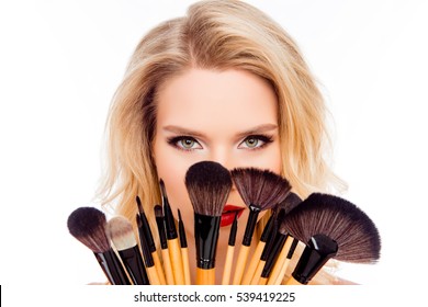 Portrait Of Young Pretty Woman Hiding Face Behind Makeup Brushes